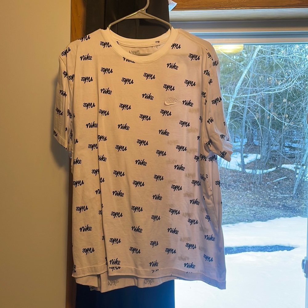 White Nike shirt with black Nike written all over it, it is XXL